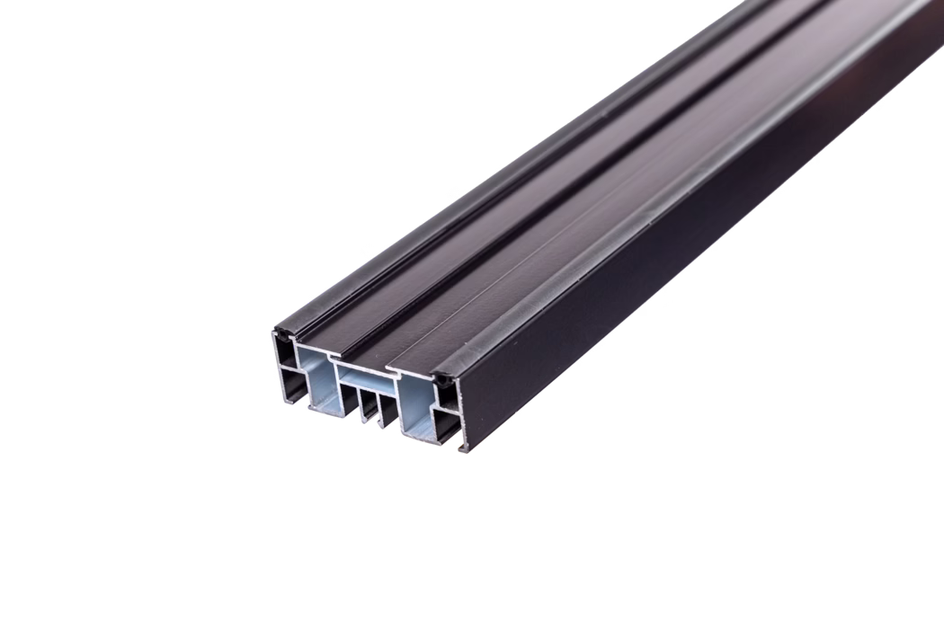 codex_Dummy_BL Rail_2024-04 Nahaufnahme eines schwarz eloxierten Aluminiumprofils mit mehreren Hohlkammern und Längsnuten, diagonal auf weißem Hintergrund dargestellt. Der Querschnitt zeigt Innenrippen und Hohlräume, typisch für Fenster- und Türrahmen oder architektonische Profile.